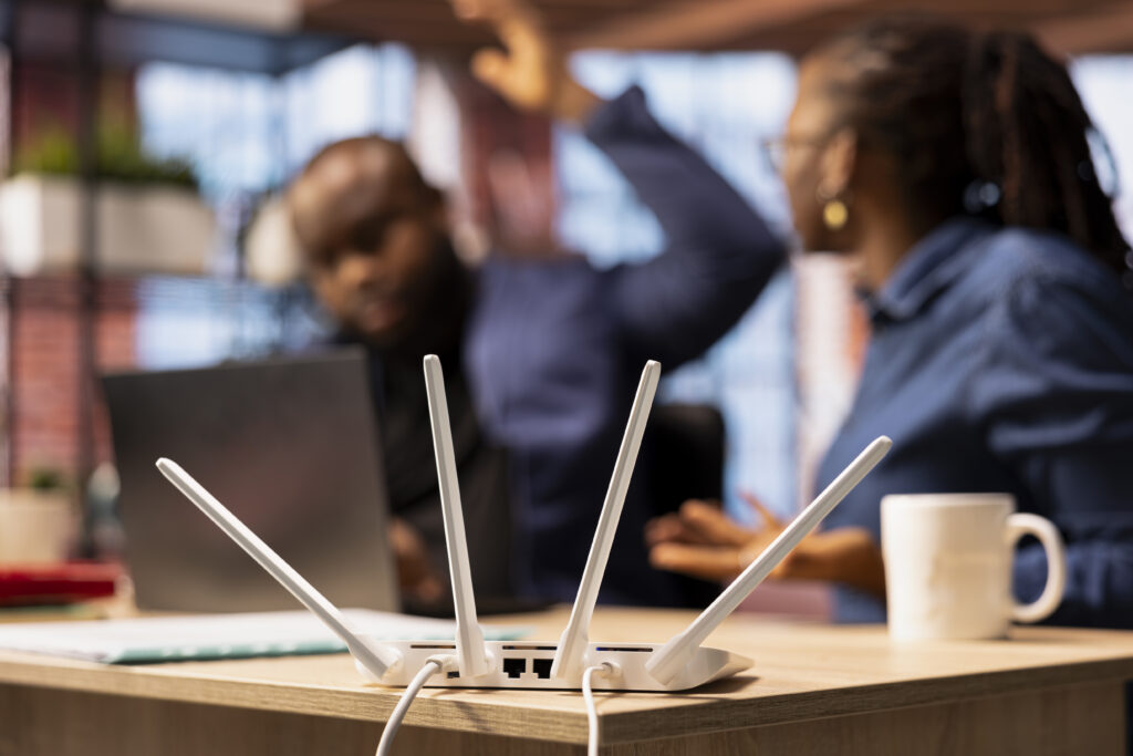 Irritated African American man struggling to reach the internet provider to help fix the signal loss issues, freelancers working at home with an unstable Wi Fi connection. Troubleshooting.